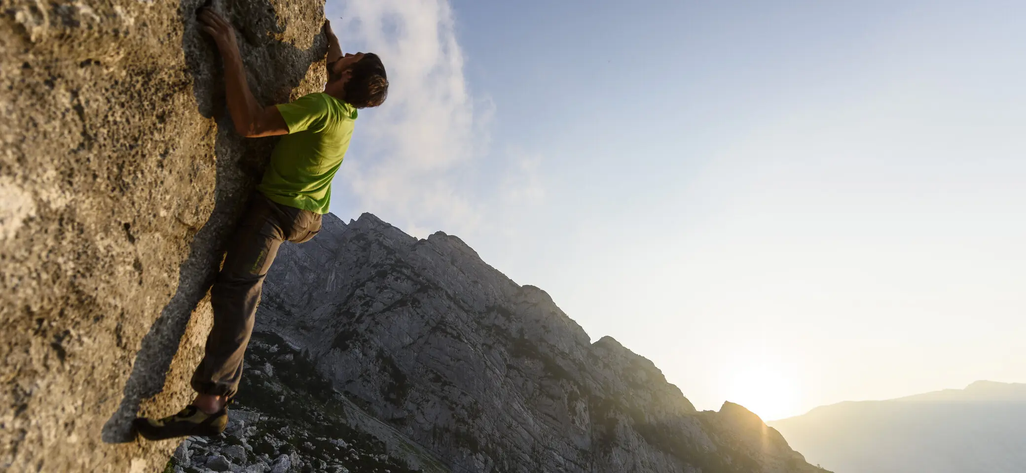 Ein Mann beim Bouldern am Fels im Sonnenuntergang | © DAV/Wolfgang Ehn