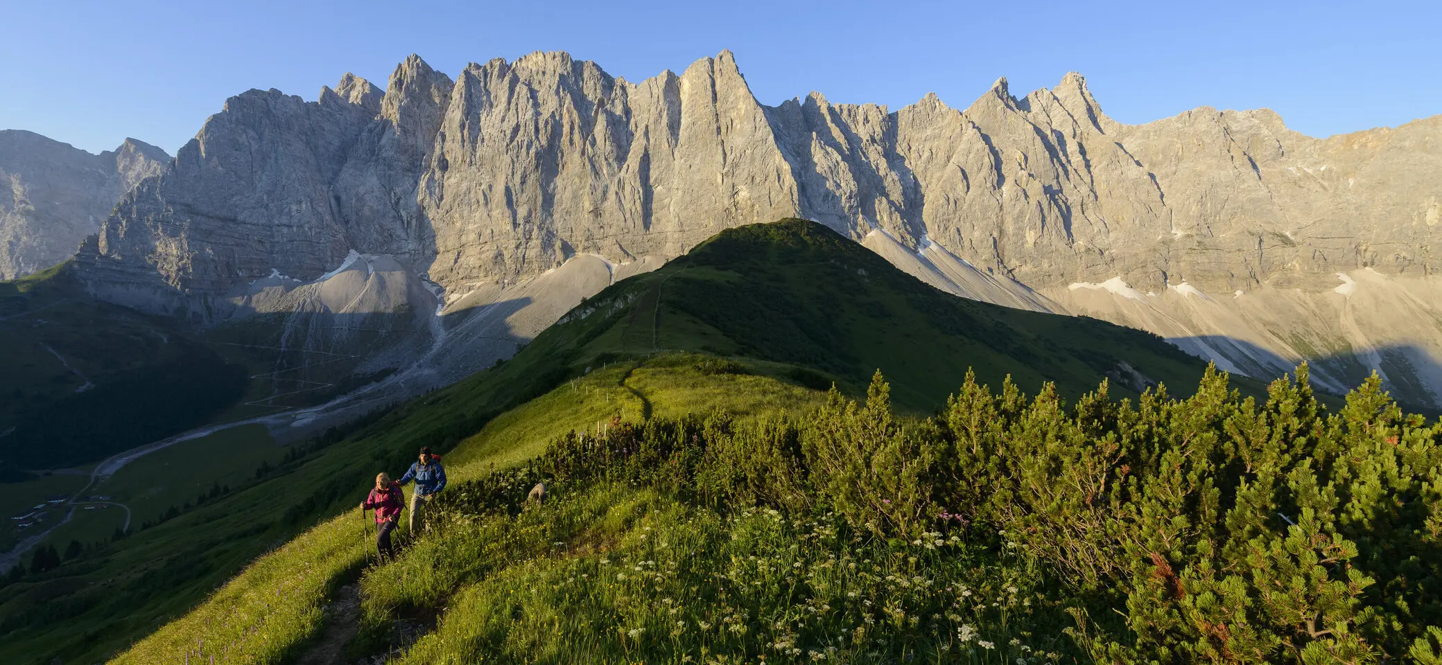 Panoramaaufname von Berggipfeln mit zwei Wanderern | © DAV/Wolfgang Ehn