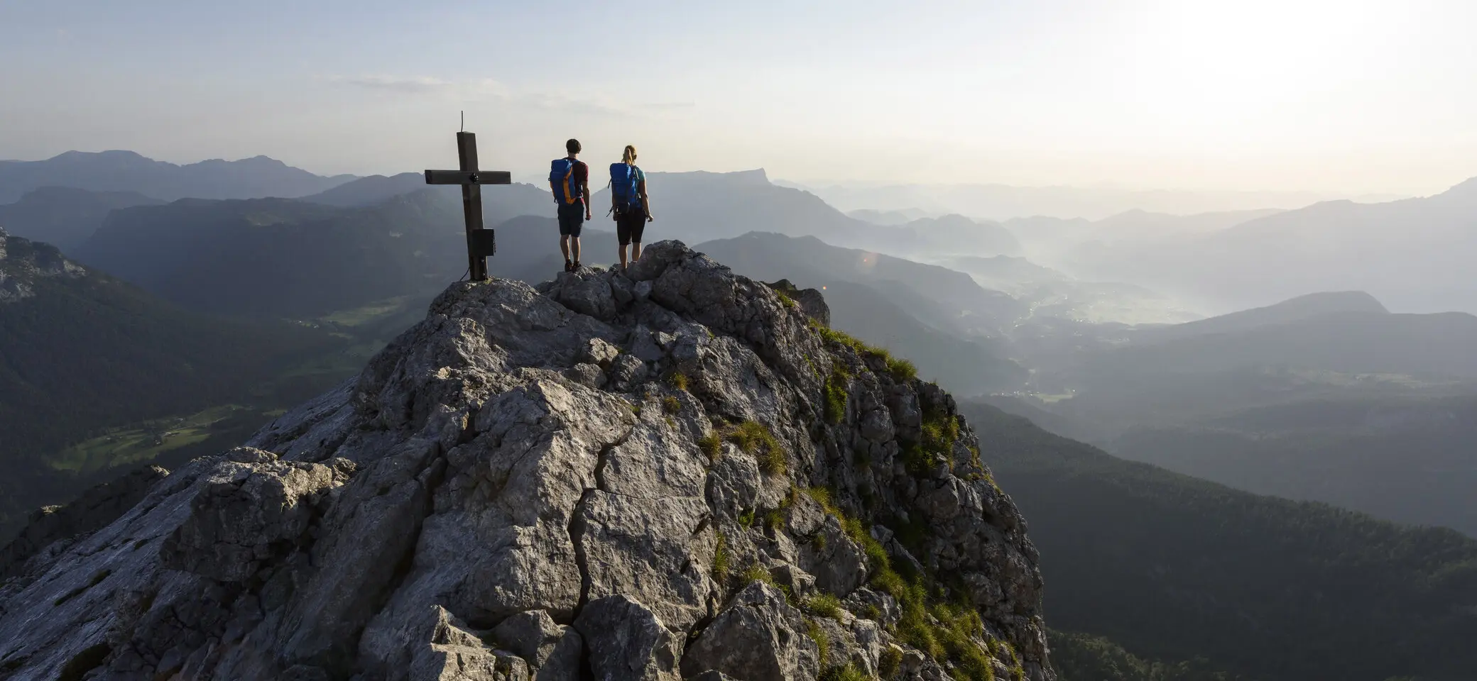 Auf dem Gipfel: Zwei Wanderer aus der Ferne auf eine Berggipfel | © DAV/Wolfgang Ehn